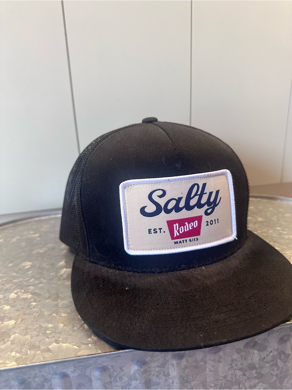 The Classic Black Trucker Hat with Salty Rodeo Patch